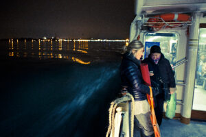 Venice - night photo on a waterbus with St. Mark's lights in background, color landscape photo