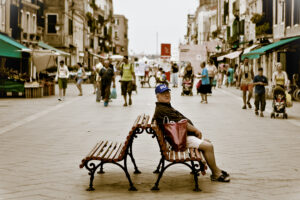 Venice - old man sitting on a bench in Via Garibaldi, color landscape photo