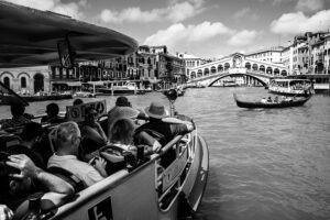 Venice - tourists on waterbus approaching Rialto Bridge, black and white landscape photo