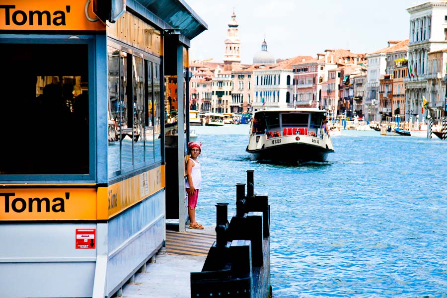 Venice - little girl waiting for the waterbus in Grand Canal, color landscape photo