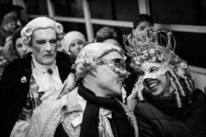 Venice - couple in carnival costumes onboard a waterbus, black and white landscape picture