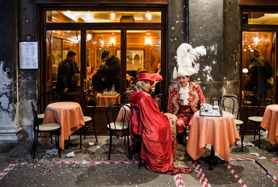 Venice - couple in carnival costumes at a cafè in St. Mark's square